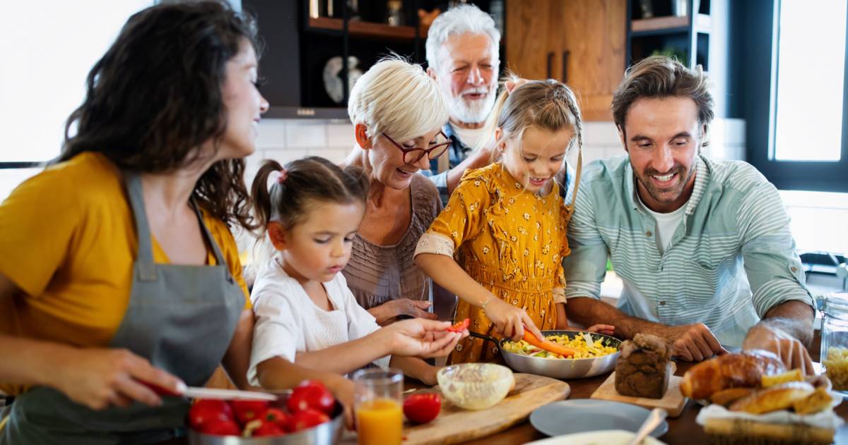 Een familie heeft het leuk samen tijdens het klaarmaken van eten in de keuken